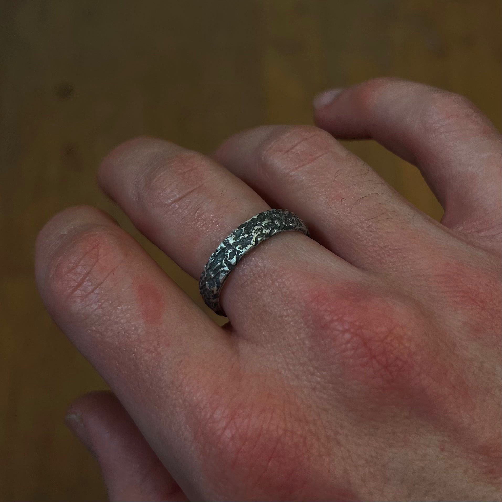 Bague Roche en argent 925 portée à la main, bijou brut et texturé fait main à Rennes, bague de pacs homme, bague de mariage homme 
