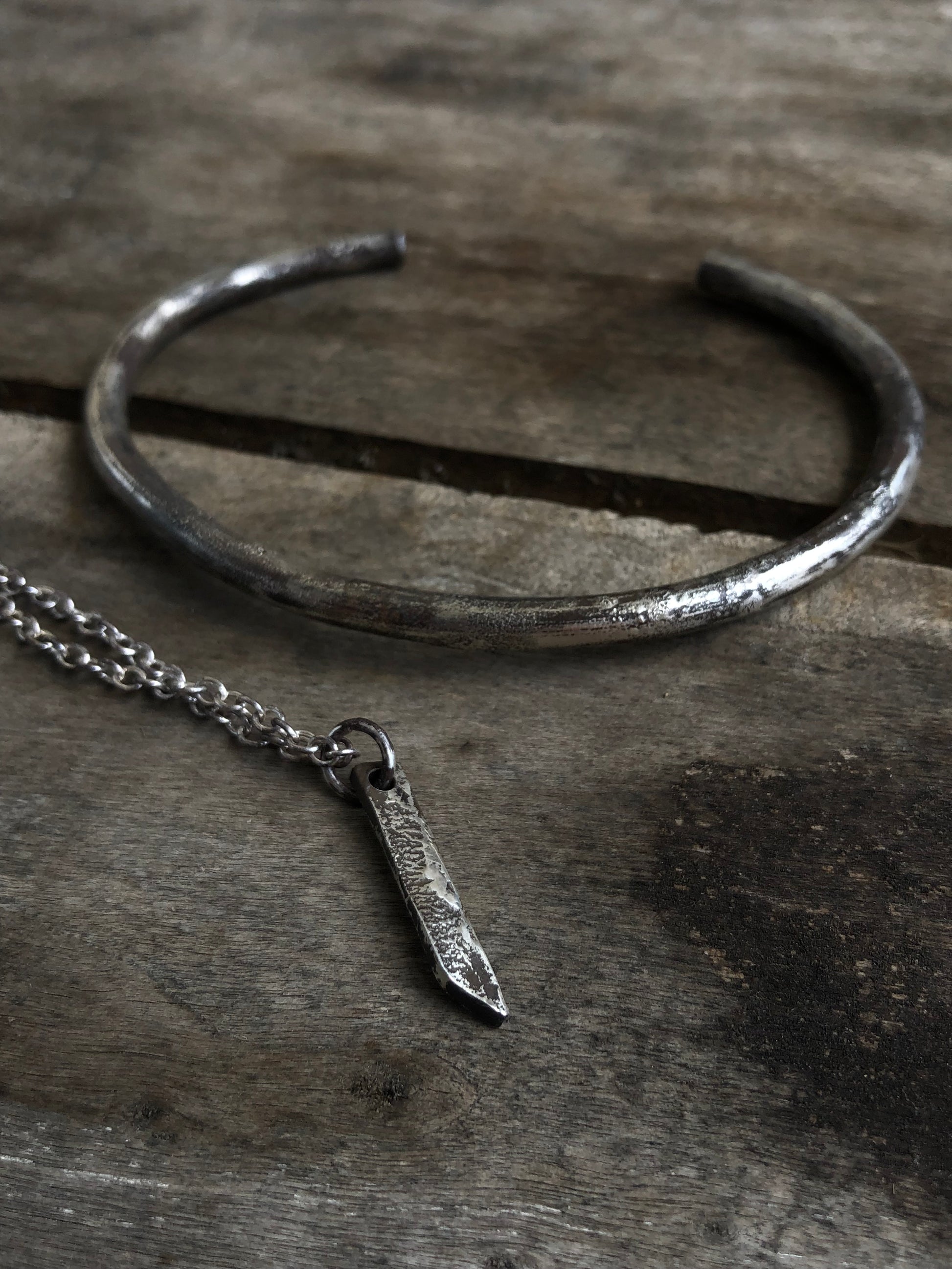 Collier en argent massif avec pendentif rectangulaire, doté d'une texture brute obtenue par la technique de réticulation, un bijou artisanal au style distinctif.