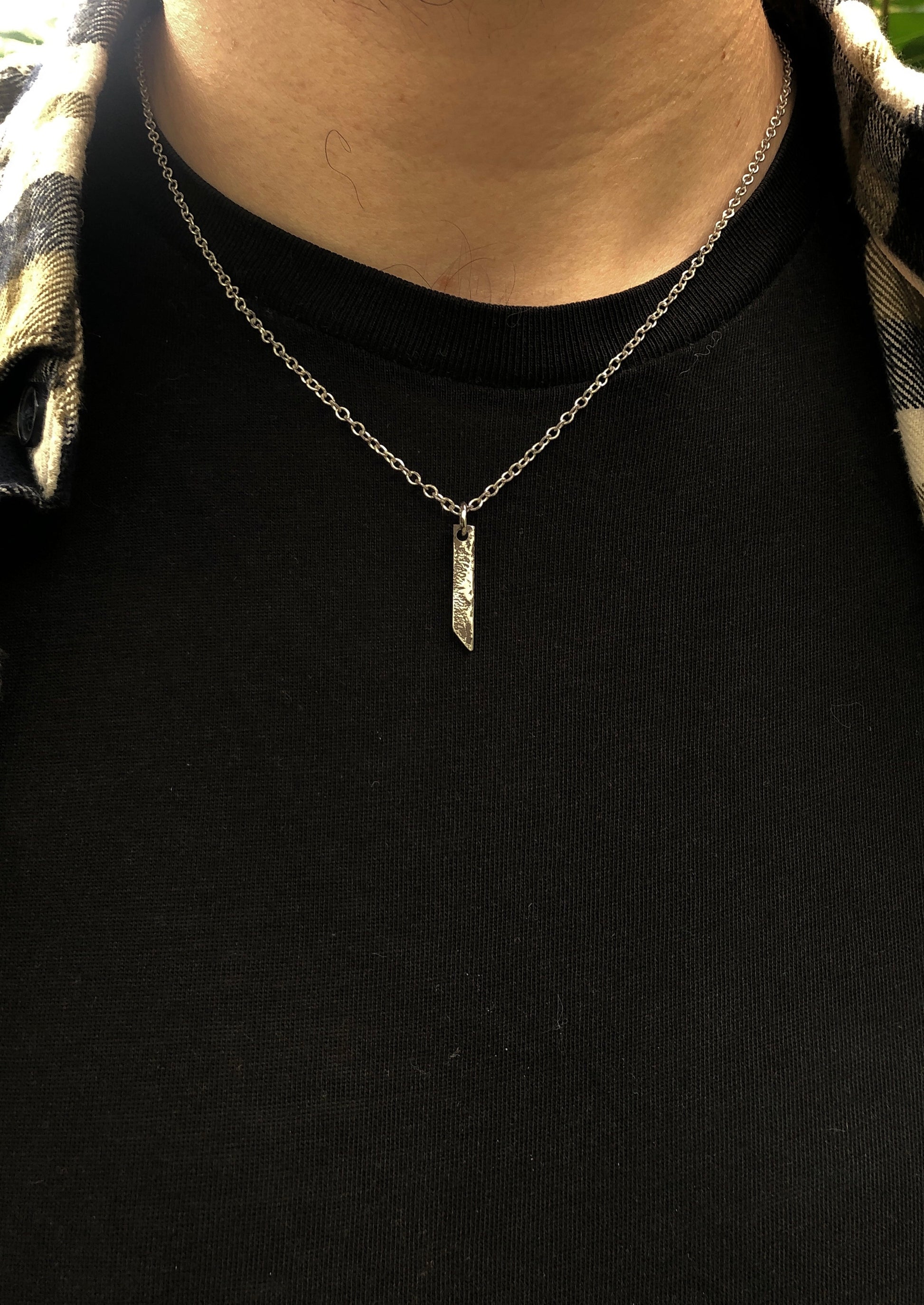 Collier en argent massif avec pendentif rectangulaire, doté d'une texture brute obtenue par la technique de réticulation, un bijou artisanal au style distinctif.