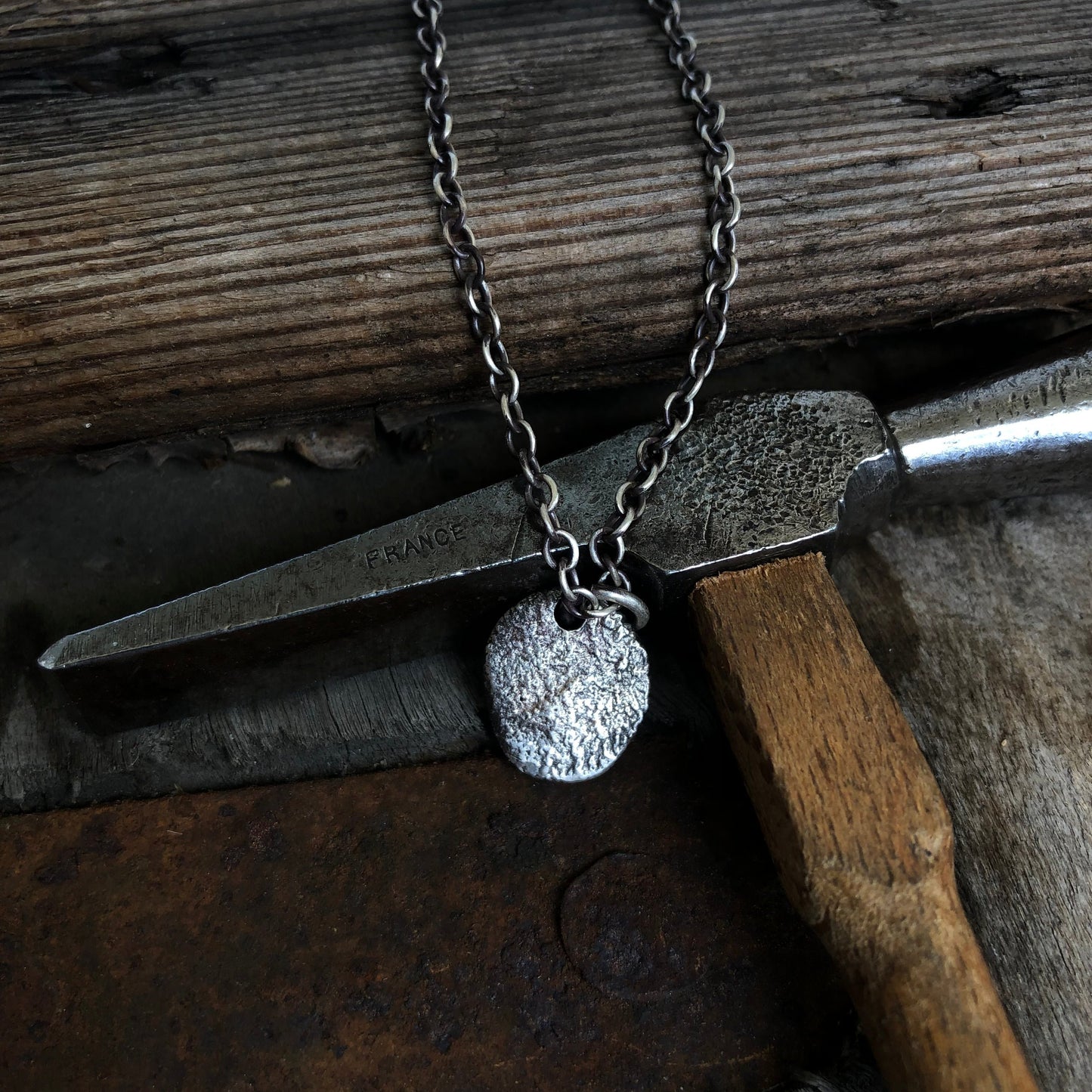 Collier en argent massif avec pendentif arrondi texturé, fabriqué avec la technique de réticulation, offrant une allure élégante et un design artisanal unique.