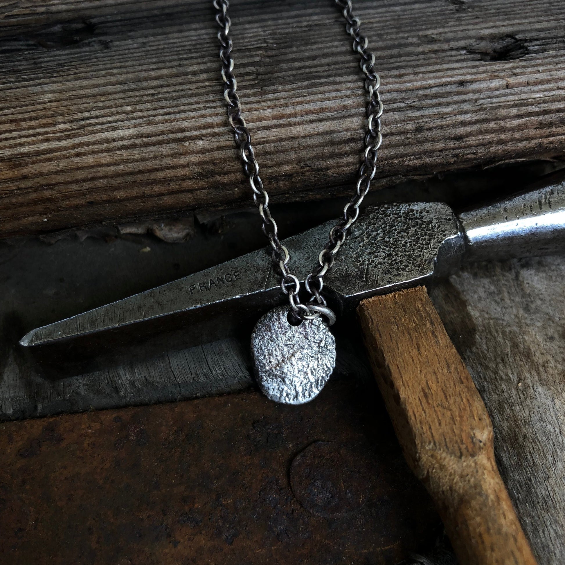 Collier en argent massif avec pendentif arrondi texturé, fabriqué avec la technique de réticulation, offrant une allure élégante et un design artisanal unique.