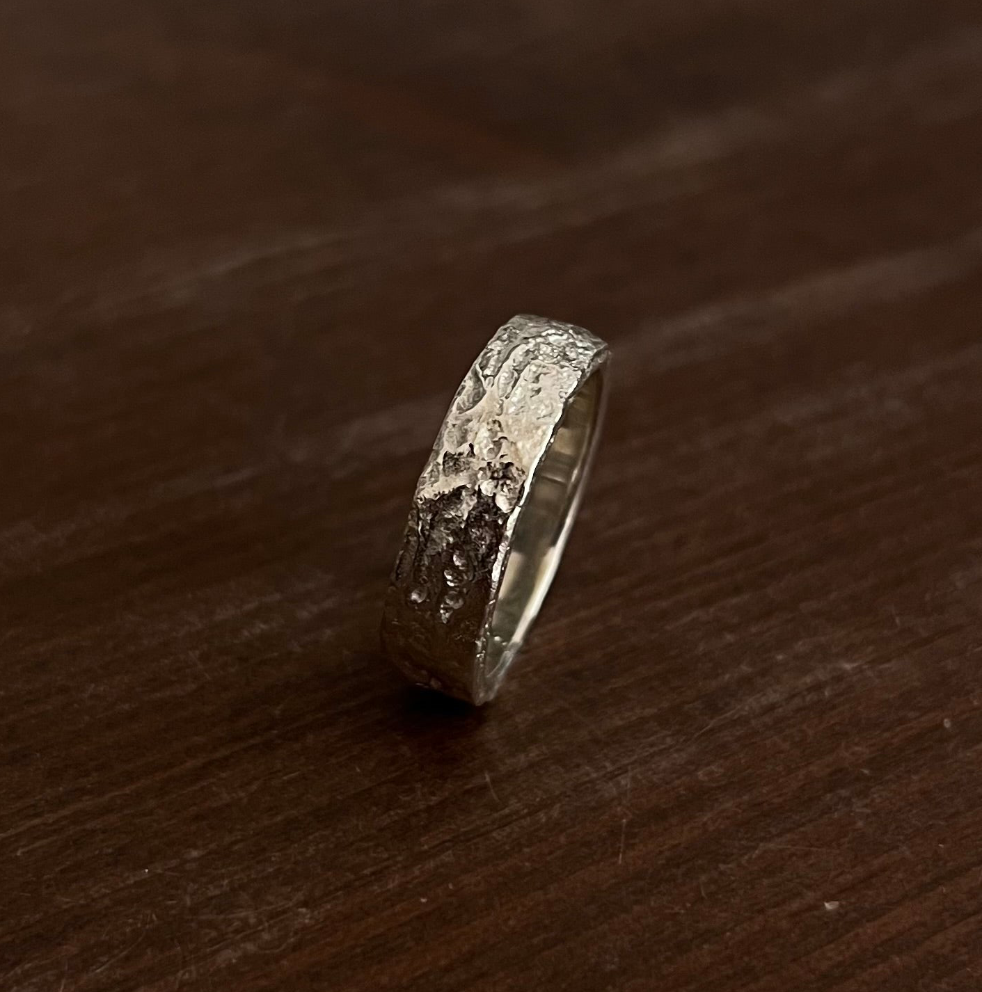 Profil de la bague texturée en argent massif 925, fabriquée à la main grâce à la fonte au sable.