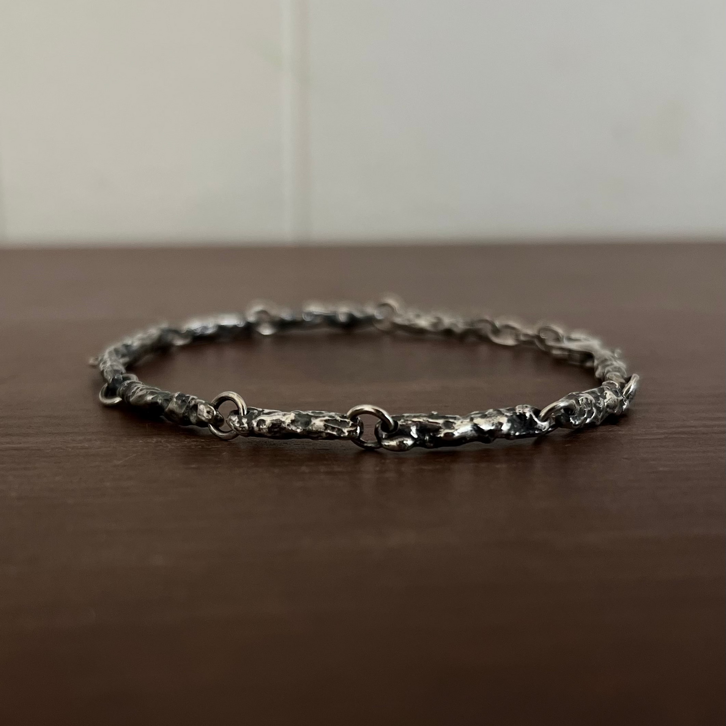 Gros plan texture érodée bracelet argent 925, reliefs naturels fonte au sable, raw jewelry artisanal Fonte Bijoux Rennes