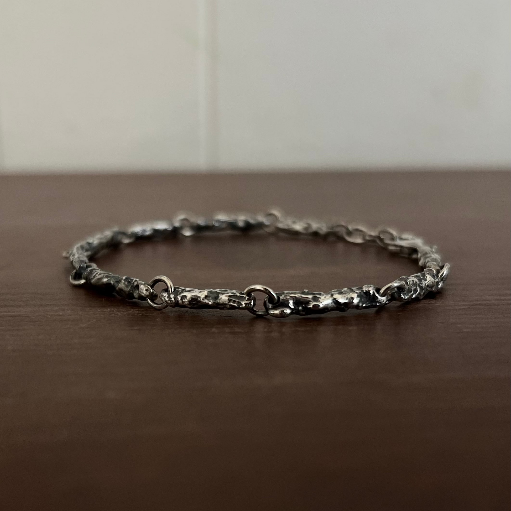 Gros plan texture érodée bracelet argent 925, reliefs naturels fonte au sable, raw jewelry artisanal Fonte Bijoux Rennes