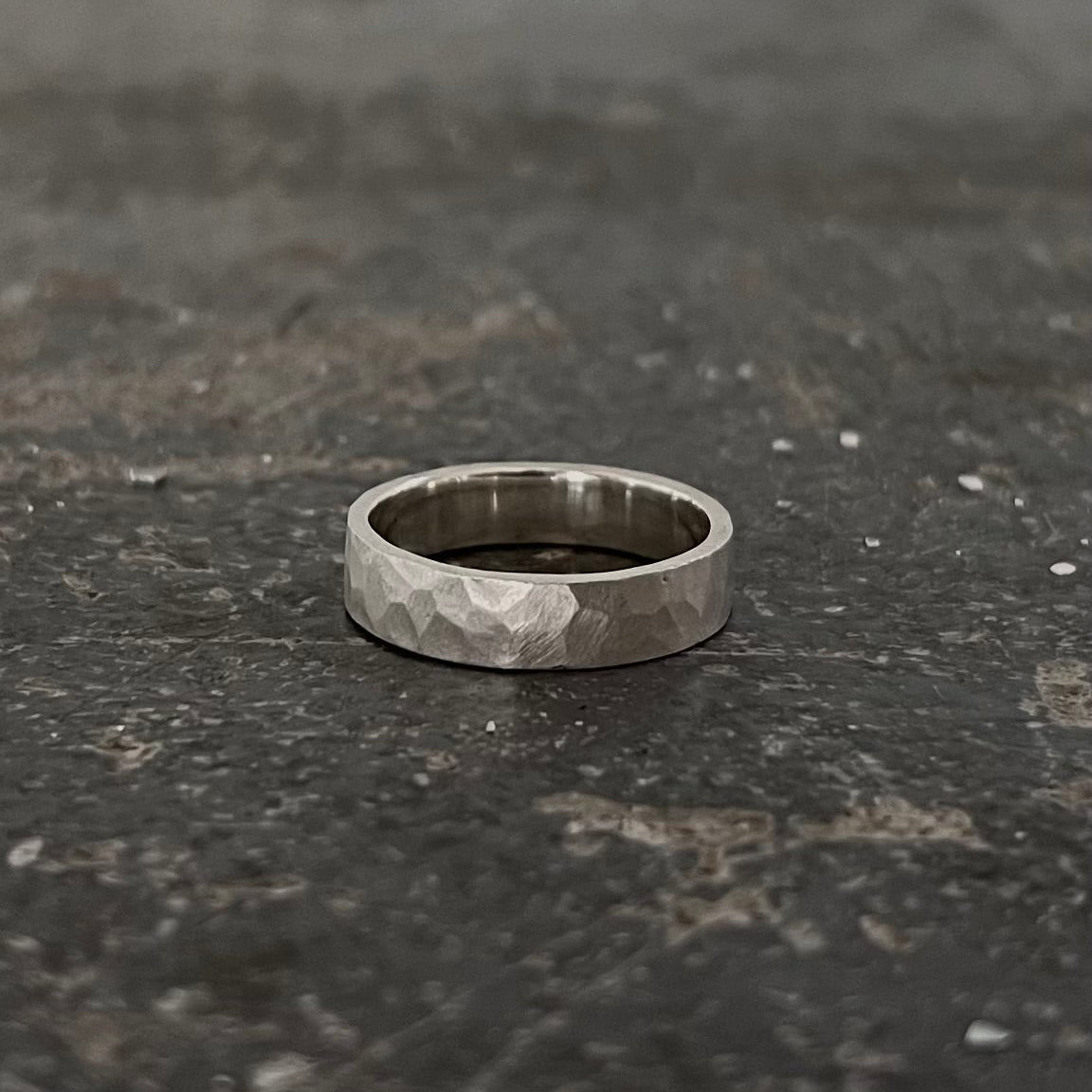 Gros plan surface martelée anneau argent 925 — texture forgée brute et déstructurée, raw jewelry atelier Fonte Bijoux Rennes