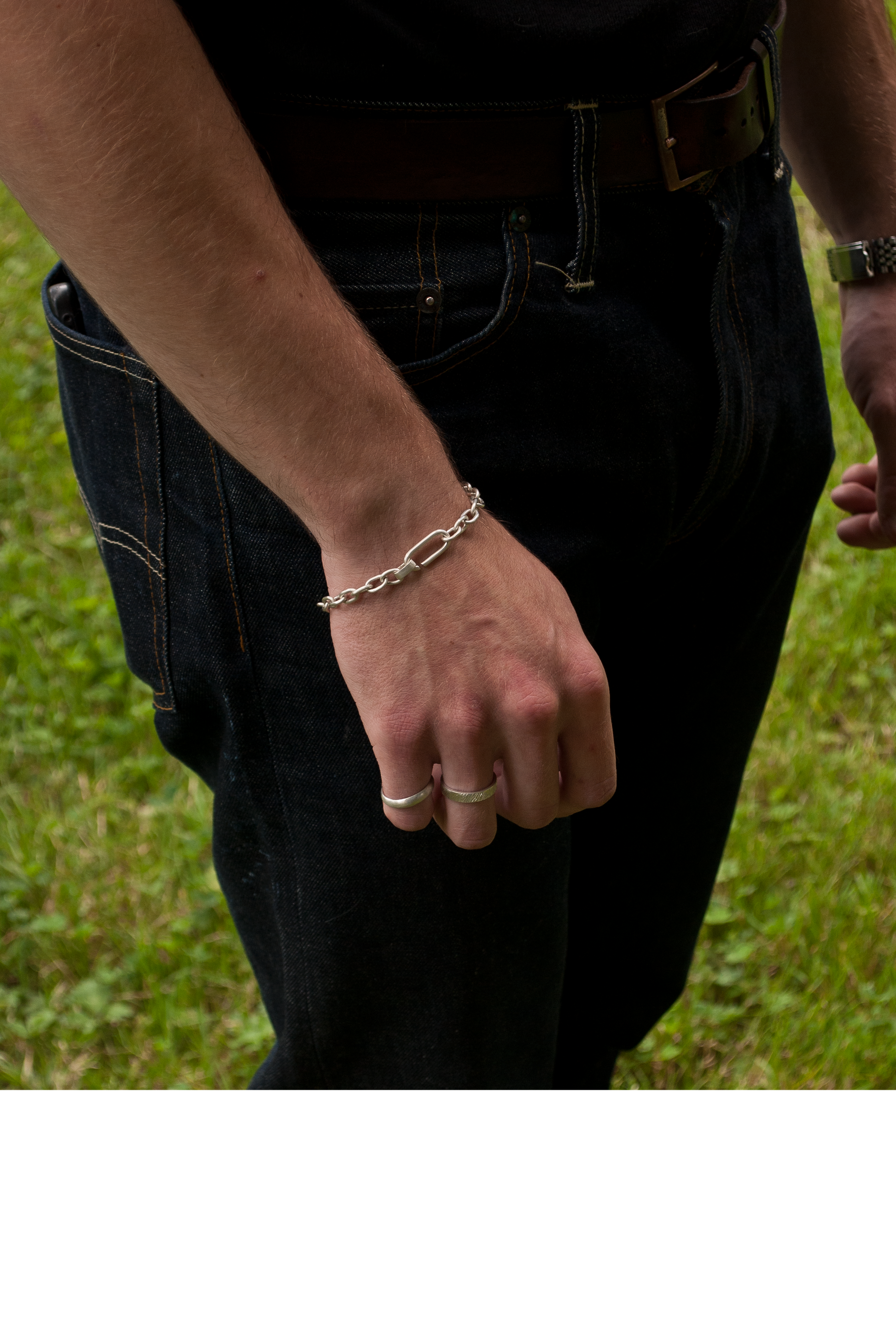 Bracelet chaîne en argent pour homme - Accessoire élégant et moderne - Porté avec un jean denim et un t-shirt noir - Idéal pour un style décontracté et tendance - Bijoux en argent de haute qualité - Parfait pour compléter votre tenue avec une touche de sophistication - Disponible en ligne chez Fontebijoux.com 